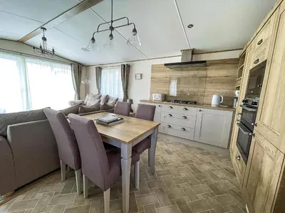 a living room with a couch and a table with chairs at Modern Caravan With Large Decking Area, Ref 60057Ch in Saxmundham