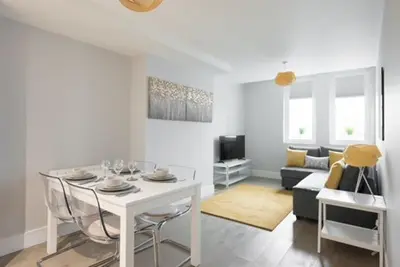 a living room with a white table and a couch at S/KING BED ONE BEDROOM FLAT in Brentwood