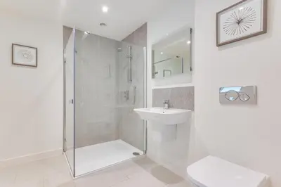 a white bathroom with a shower and a sink at 3 Bed in Snape oc-1wadd in Snape