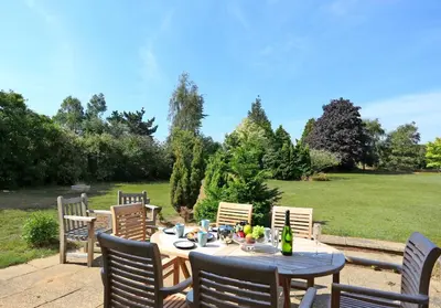a patio with a table and chairs and a field at 3 Bed in Aldeburgh oc-10nw in Aldeburgh