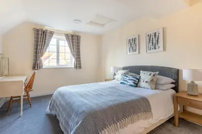 a bedroom with a bed and a desk and a window at 4 Bed in Thorpeness oc-bays in Thorpeness