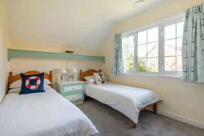 two beds in a room with two windows at 4 Bed in Thorpeness oc-bays in Thorpeness