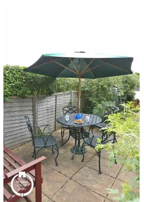 a table and chairs with an umbrella on a patio at 2 Bed in Aldeburgh oc-prd in Aldeburgh