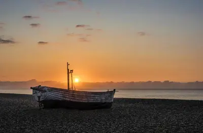 a boat sitting on the beach at sunset at 2 Bed in Aldeburgh oc-prd in Aldeburgh
