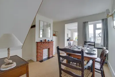a dining room and living room with a table and a fireplace at 2 Bed in Aldeburgh oc-prd in Aldeburgh