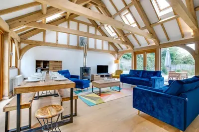 a living room with blue couches and a table at 4 Bed in Eastbridge oc-bricot in Theberton