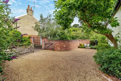 a garden with a brick wall and a gate at 2 Bed in Yoxford oc-c27253 in Wickham Market