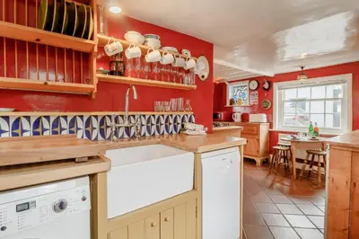 a kitchen with red walls and a white dishwasher at 4 Bed in Aldeburgh oc-sfcrr in Aldeburgh