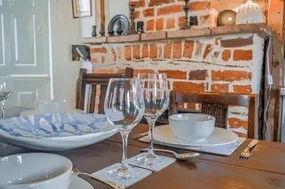 a table with two wine glasses on top of it at 2 Bed in Aldeburgh oc-sfdar in Aldeburgh
