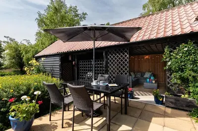 a patio with a table and chairs and an umbrella at 2 Bed in Rumburgh oc-dgf in Rumburgh