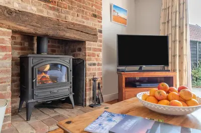 a living room with a stove and a bowl of fruit at 3 Bed in Westleton Saxmundham oc-est in Westleton