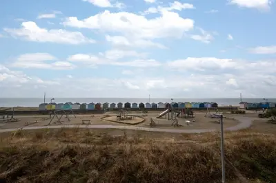 a park with a playground with the ocean in the background at 3 Bed in Felixstowe oc-fel in Felixstowe