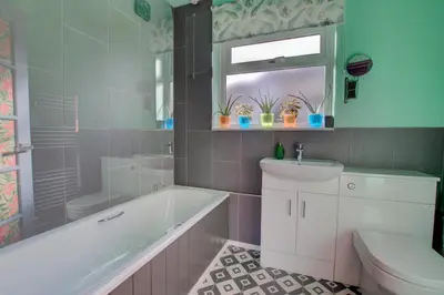 a bathroom with a tub and a toilet and a sink at 2 Bed in Felixstowe oc-hideo in Felixstowe