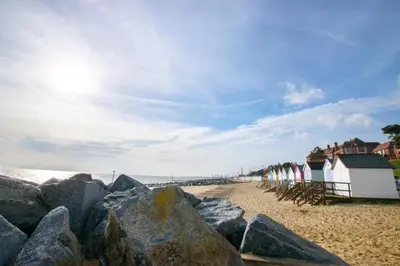 a group of rocks on a sandy beach with surfboards at 2 Bed in Felixstowe oc-hideo in Felixstowe