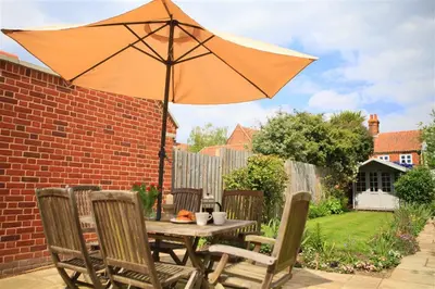 a table and chairs with an umbrella on a patio at 2 Bed in Orford oc-sflis in Orford