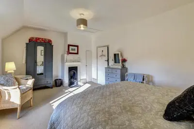 a bedroom with a bed and a dresser and a fireplace at 2 Bed in Orford oc-sflis in Orford