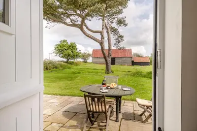 an open door to a patio with a table and chairs at 2 Bed in Sudbourne oc-lodbu in Sudbourne