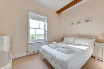 a white bedroom with a bed and a window at 4 Bed in Halesworth oc-mdh in Blythburgh