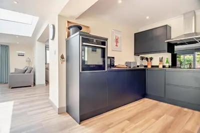 a kitchen with black cabinets and a counter top at 7 Bed in Aldeburgh oc-midba in Aldeburgh