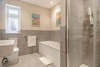 a bathroom with a tub and a toilet and a sink at 7 Bed in Aldeburgh oc-midba in Aldeburgh