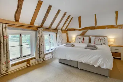 a bedroom with a large white bed and windows at 5 Bed in Finningham oc-obhf in Finningham
