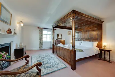 a bedroom with a canopy bed and a fireplace at 4 Bed in Orford oc-obh2 in Orford