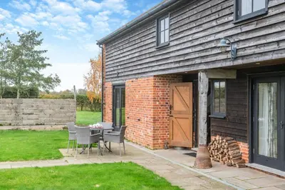 a patio with a table and chairs next to a building at 2 Bed in Yoxford oc-hploug in Yoxford