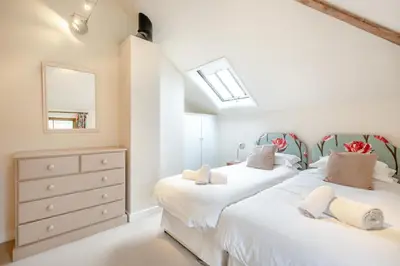 a bedroom with two beds and a dresser and a mirror at 2 Bed in Yoxford oc-hploug in Yoxford
