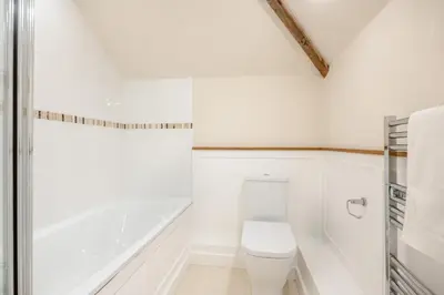 a white bathroom with a toilet and a bath tub at 2 Bed in Yoxford oc-hploug in Yoxford