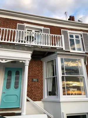 a brick house with a blue door and a balcony at 3 Bed in Aldeburgh oc-reg in Aldeburgh
