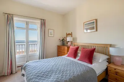 a bedroom with a bed with a view of the ocean at 3 Bed in Aldeburgh oc-reg in Aldeburgh
