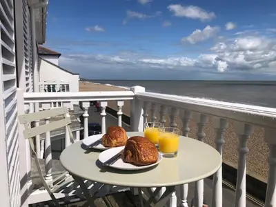 a table on a balcony with two glasses of orange juice at 3 Bed in Aldeburgh oc-reg in Aldeburgh