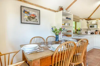a kitchen and dining room with a wooden table and chairs at 3 Bed in All Saints South Elmham oc-sfspw in Saint James