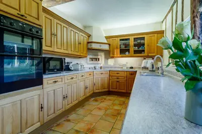 a kitchen with wooden cabinets and a vase with a plant at 5 Bed in Metfield oc-stfarm in Metfield