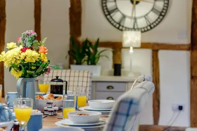 a table with a plate of food and a clock at 5 Bed in Metfield oc-stfarm in Metfield