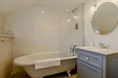 a white bathroom with a tub and a sink at 4 Bed in Westleton oc-s27303 in Westleton