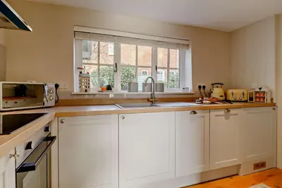 a kitchen with white cabinets and a sink and a window at 4 Bed in Westleton oc-s27303 in Westleton