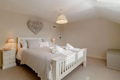 a bedroom with a white bed with towels on it at 4 Bed in Westleton oc-s27303 in Westleton