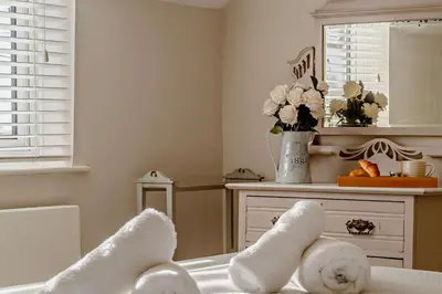 a room with white towels and a table with a mirror at 4 Bed in Westleton oc-s27303 in Westleton