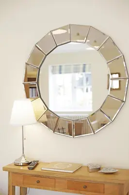 a mirror on a wall above a table with a lamp at 2 Bed in Eye oc-slo in Wilby