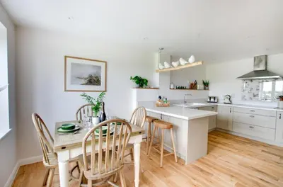 a kitchen with white cabinets and a table and chairs at 2 Bed in Newton oc-swro in Sudbury