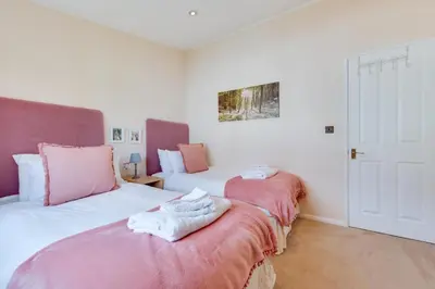 a bedroom with two beds with pink and white sheets at 2 Bed in Aldeburgh oc-har in Aldeburgh