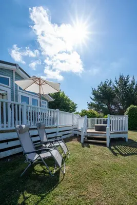 a couple of chairs and an umbrella next to a fence at 2 Bed in Aldeburgh oc-har in Aldeburgh