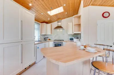 a kitchen with white cabinets and a wooden ceiling at 2 Bed in Aldeburgh oc-har in Aldeburgh