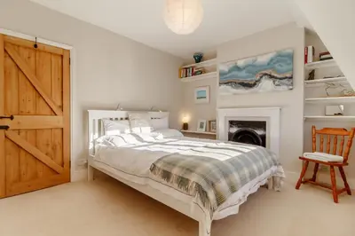 a white bedroom with a bed and a fireplace at 2 Bed in Orford oc-sflpo in Orford