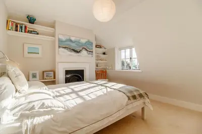 a white bedroom with a bed and a fireplace at 2 Bed in Orford oc-sflpo in Orford