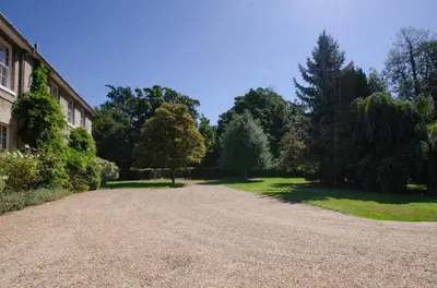 a driveway leading to a building with trees in the background at 13 Bed in Tattingstone oc-tat26 in Tattingstone