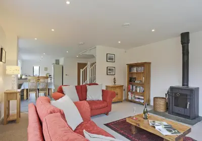 a living room with a red couch and a stove at 2 Bed in Leiston oc-cqa in Theberton