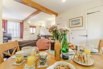 a dining room table with flowers and bottles on it at 3 Bed in Woodbridge oc-h23 in Woodbridge