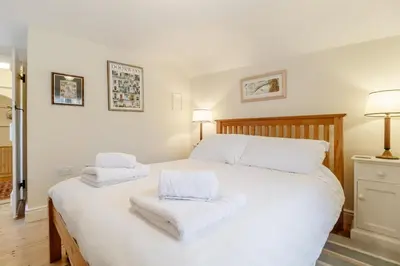 a bedroom with a large white bed with towels on it at 3 Bed in Woodbridge oc-h23 in Woodbridge